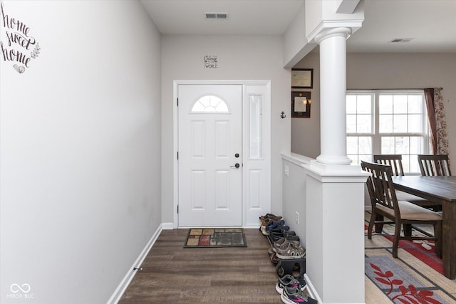 entrance foyer featuring baseboards, wood finished floors, visible vents, and ornate columns