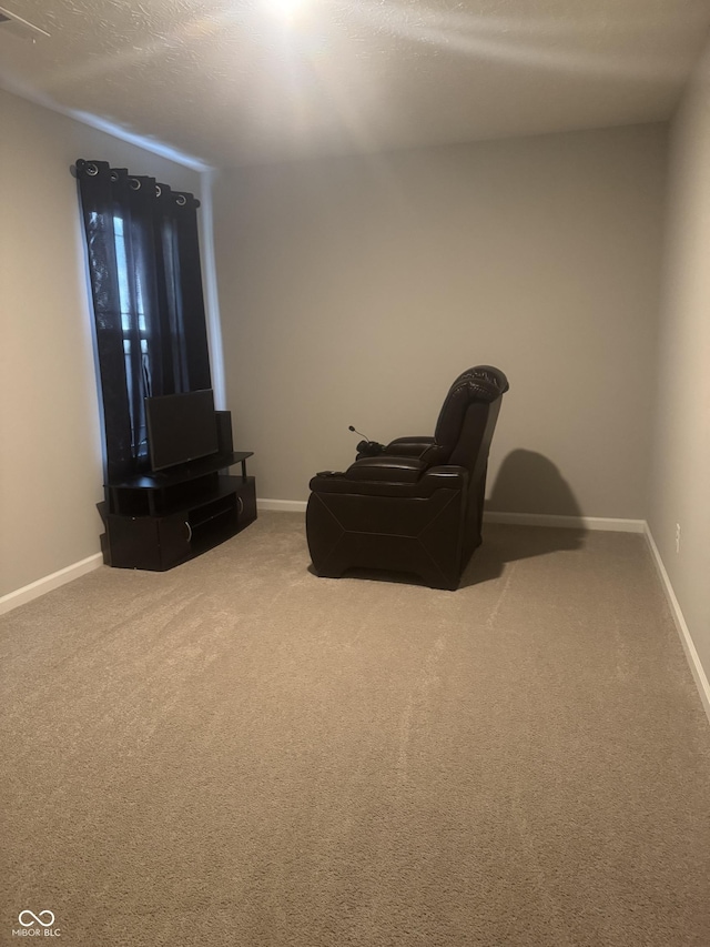 living area featuring a textured ceiling, carpet, visible vents, and baseboards