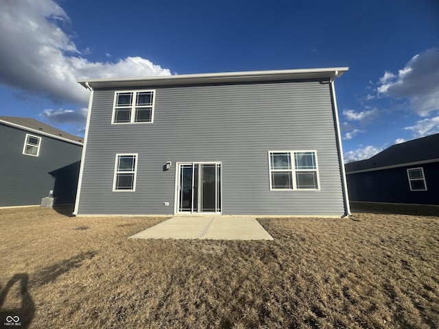 back of house with a patio and a lawn