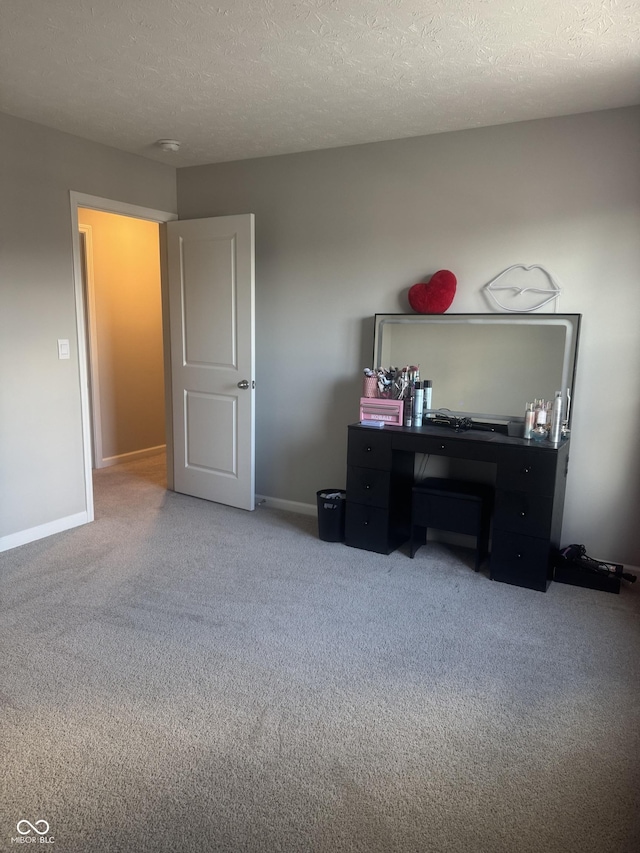 home office featuring carpet flooring, a textured ceiling, and baseboards