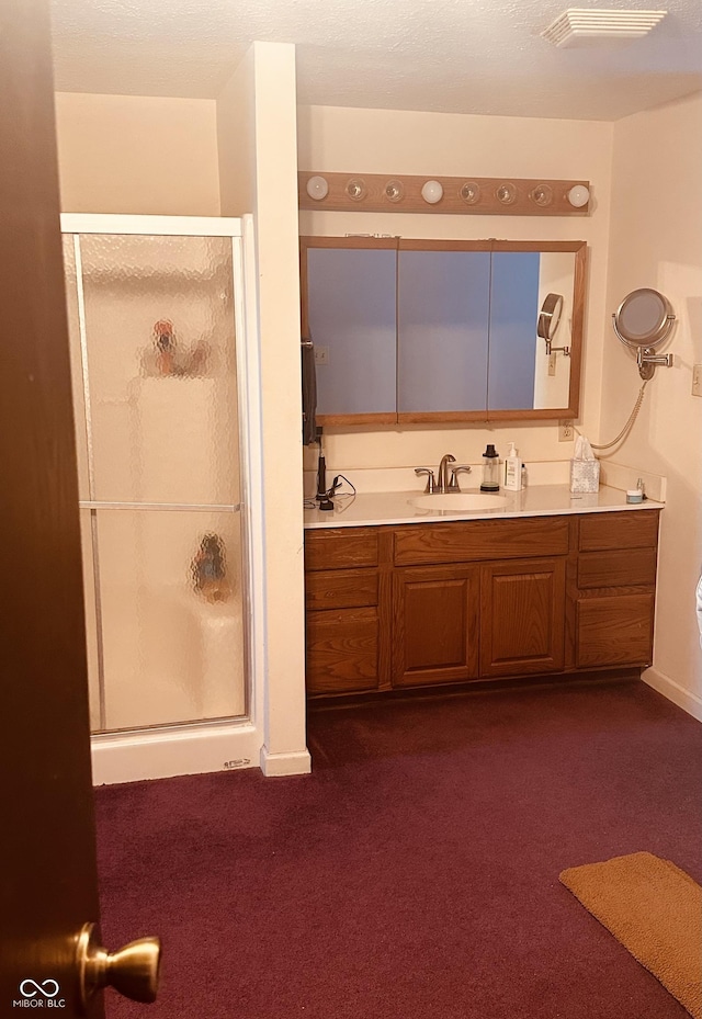 bathroom featuring a stall shower, vanity, visible vents, and baseboards