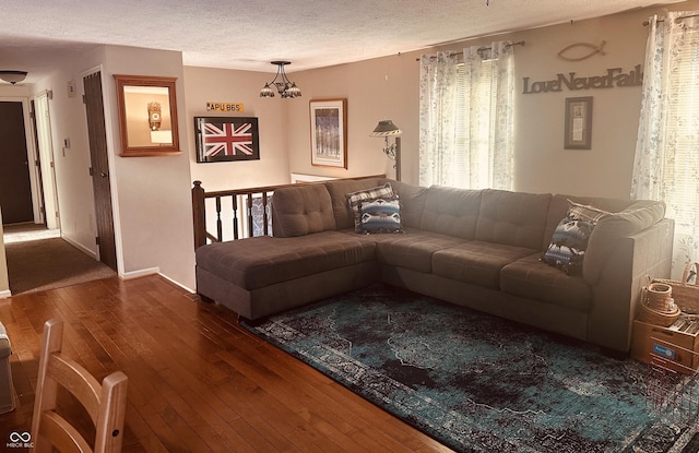 living room featuring baseboards, a textured ceiling, and hardwood / wood-style floors