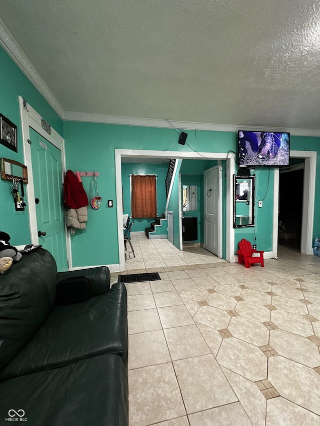 living room featuring light tile patterned floors, crown molding, a textured ceiling, and stairs