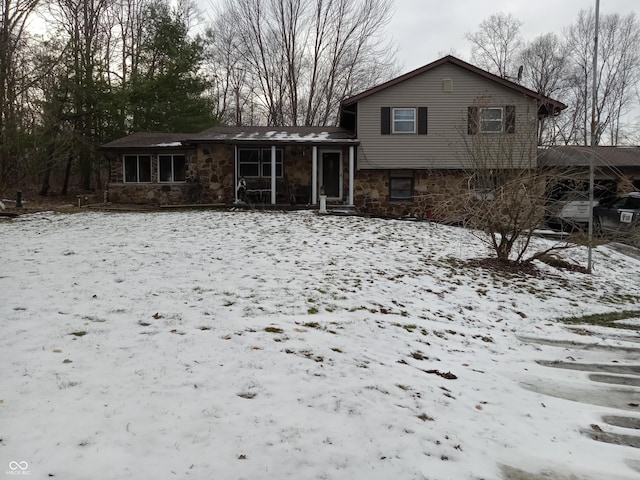 snow covered house with stone siding