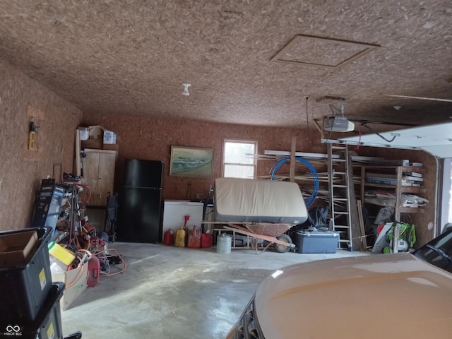 garage featuring a garage door opener and freestanding refrigerator