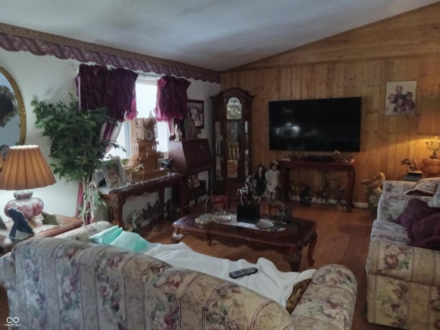 living room with vaulted ceiling, wood walls, and wood finished floors