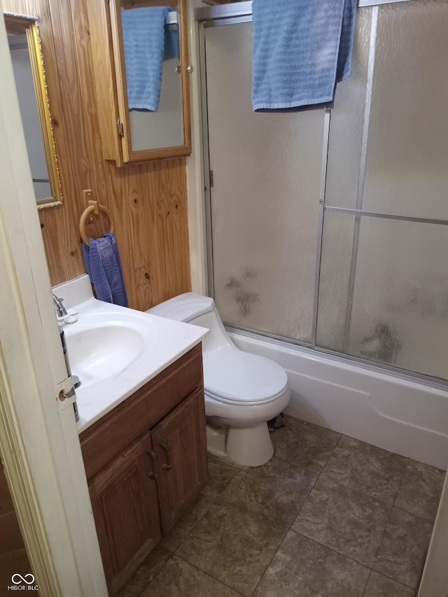 full bath with toilet, shower / bath combination with glass door, and vanity