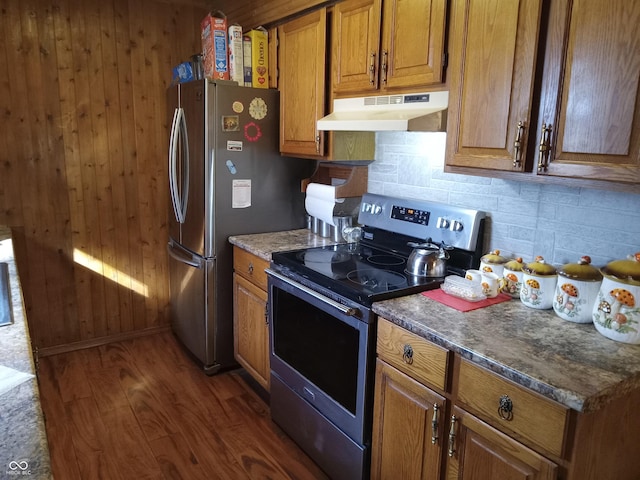 kitchen featuring stainless steel appliances, brown cabinetry, decorative backsplash, and under cabinet range hood