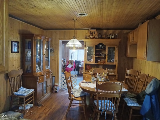 dining room featuring wooden ceiling, wooden walls, and visible vents