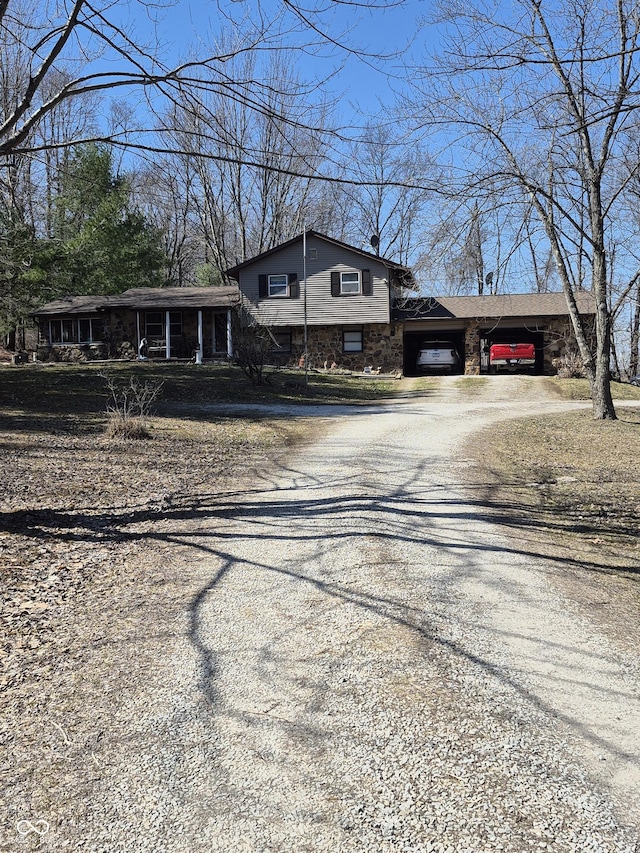 view of front facade with an attached carport and gravel driveway