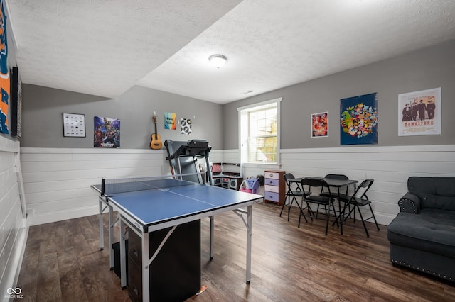 game room featuring dark wood-style floors, wainscoting, and a textured ceiling