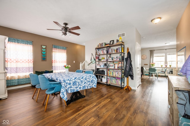 dining space with ceiling fan, visible vents, and dark wood-style flooring