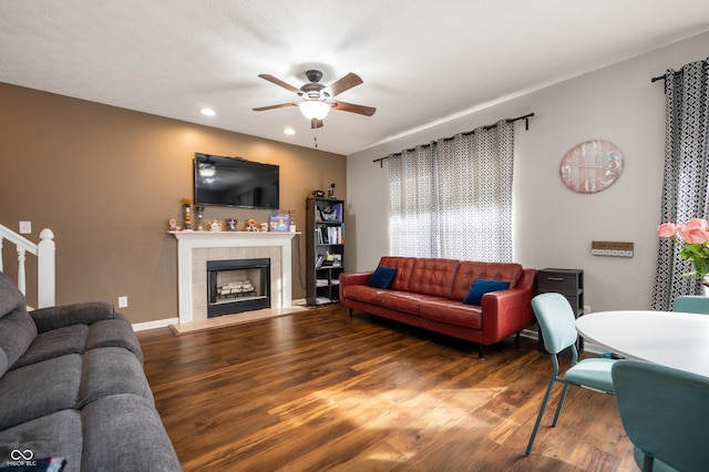 living area with baseboards, a ceiling fan, wood finished floors, a fireplace, and recessed lighting