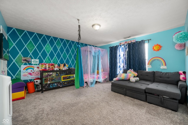 rec room featuring a textured ceiling, an accent wall, visible vents, and carpet flooring