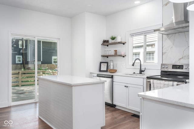 kitchen featuring stainless steel appliances, a sink, dark wood-style floors, wall chimney exhaust hood, and tasteful backsplash