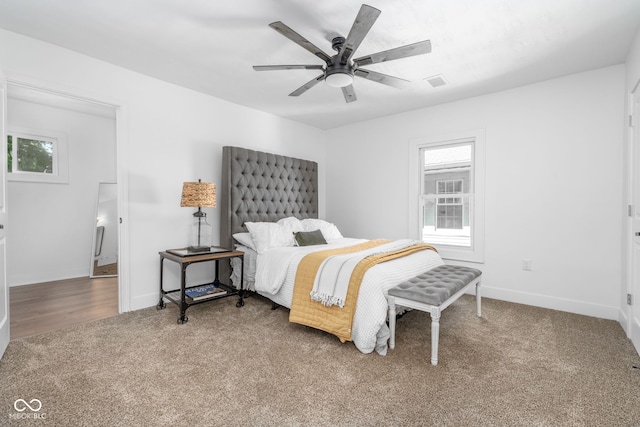 carpeted bedroom with baseboards, visible vents, and ceiling fan