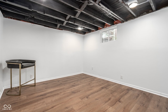 basement featuring wood finished floors and baseboards