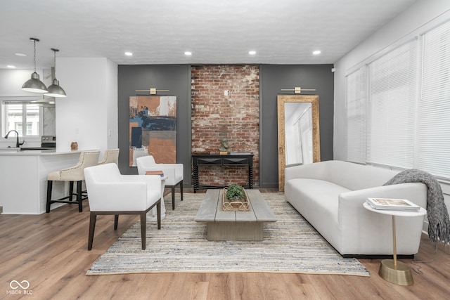 living area featuring a textured ceiling, a fireplace, wood finished floors, and recessed lighting