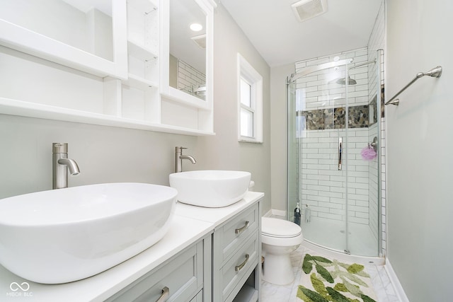 full bath featuring double vanity, a sink, visible vents, and a shower stall