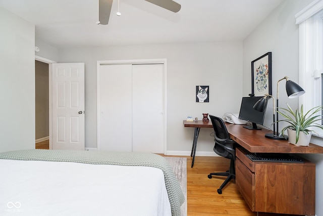 bedroom featuring ceiling fan, a closet, light wood-type flooring, and baseboards