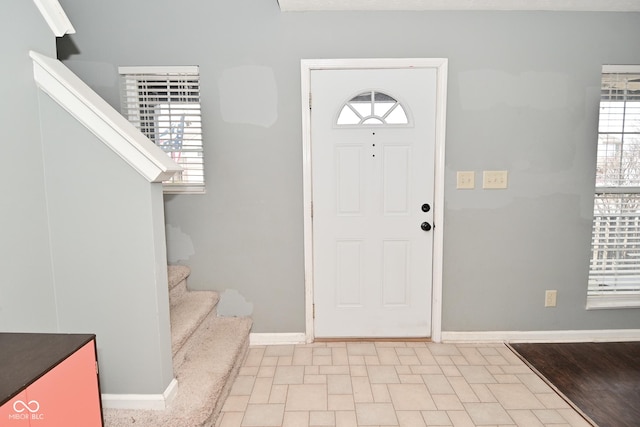 entrance foyer with baseboards and stairway