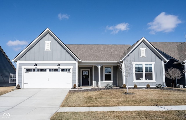 view of front of home featuring a garage, driveway, roof with shingles, a front lawn, and board and batten siding