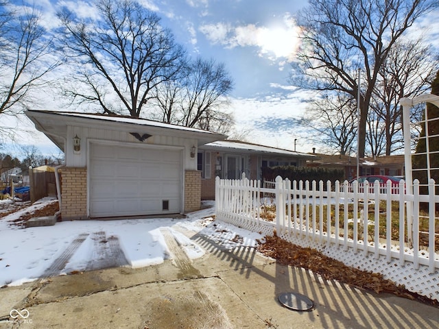 ranch-style house with an attached garage, a fenced front yard, and brick siding