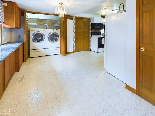 clothes washing area with a notable chandelier, laundry area, visible vents, light floors, and washer and clothes dryer