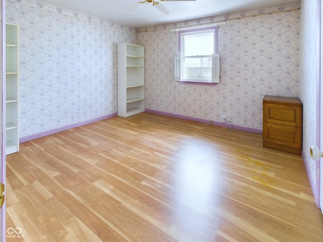 unfurnished room featuring light wood-type flooring, wallpapered walls, ceiling fan, and baseboards