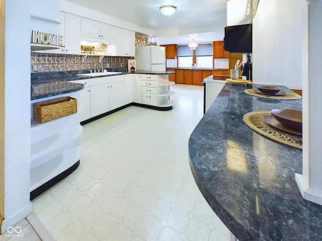 kitchen featuring white cabinets, freestanding refrigerator, light floors, open shelves, and a sink