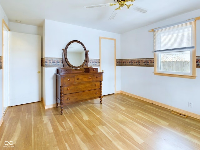 unfurnished bedroom with a ceiling fan, light wood-type flooring, visible vents, and baseboards