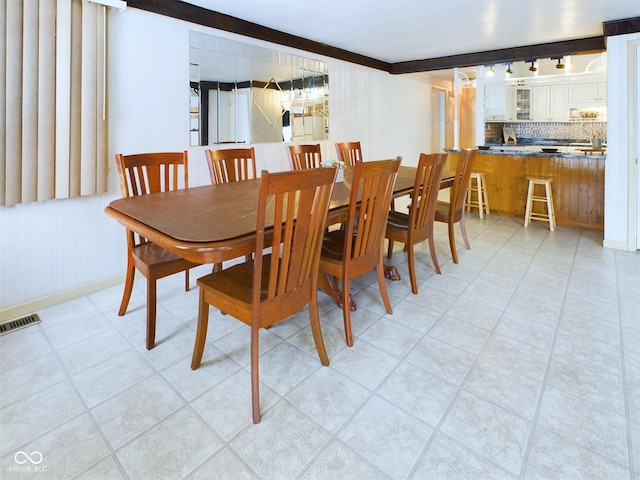 dining room featuring beam ceiling and visible vents