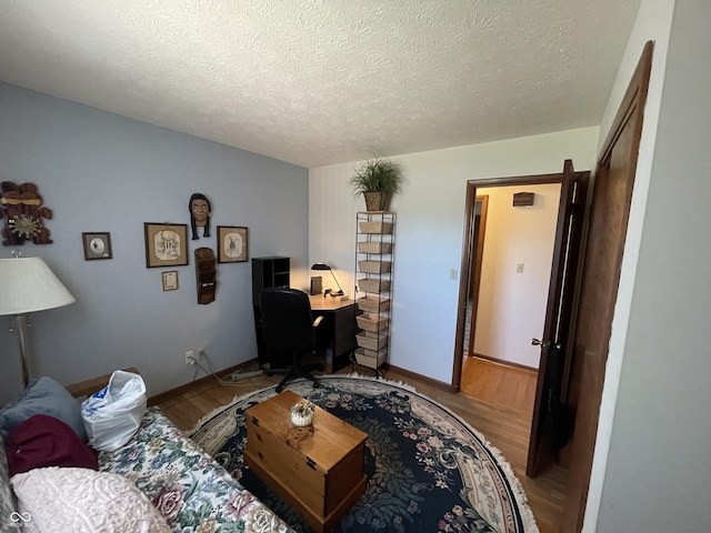 office space featuring a textured ceiling, wood finished floors, and baseboards