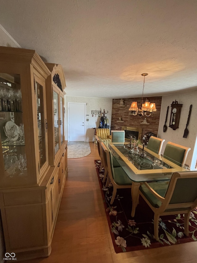 dining space with a chandelier, a textured ceiling, and wood finished floors