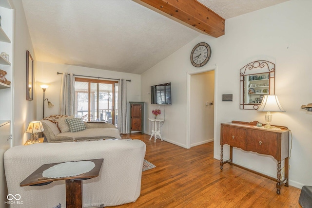 living room with lofted ceiling with beams, wood finished floors, and baseboards