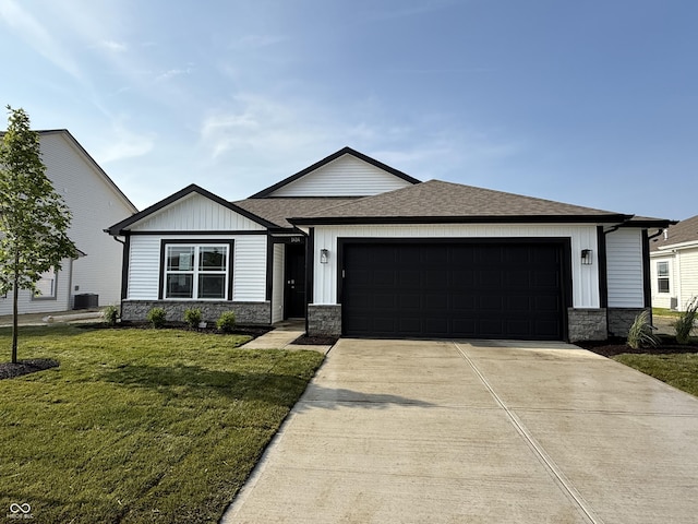 1414 Bluebonnet Pl, Shelbyville, IN 46176 - view of front of property featuring stone siding, an attached garage, concrete driveway, a front lawn, and roof with shingles