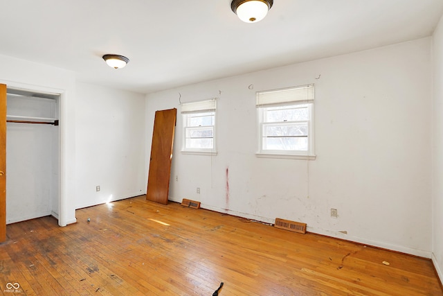 unfurnished bedroom with visible vents and wood finished floors