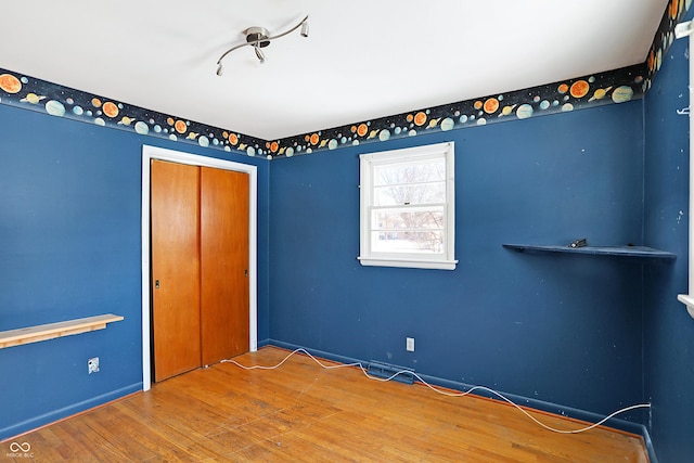 unfurnished bedroom with a closet and wood finished floors