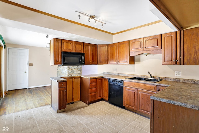 kitchen with brown cabinets, crown molding, a sink, black appliances, and baseboards