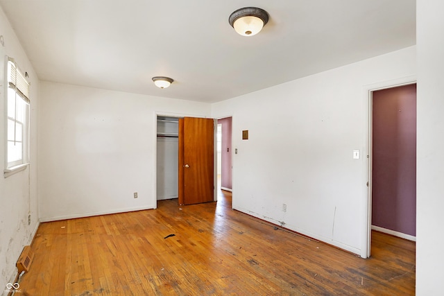 spare room featuring baseboards and wood finished floors