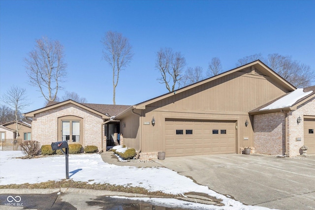 ranch-style home featuring a garage, driveway, and brick siding