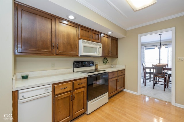 kitchen featuring white appliances, light countertops, ornamental molding, hanging light fixtures, and brown cabinets