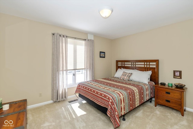 bedroom with baseboards, visible vents, and light colored carpet