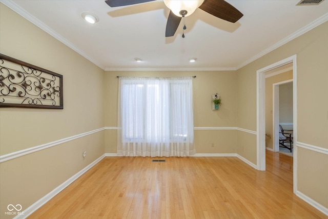 unfurnished room featuring ornamental molding, visible vents, light wood-style flooring, and baseboards