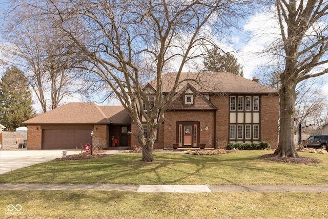 tudor house featuring brick siding, a shingled roof, an attached garage, a front yard, and driveway