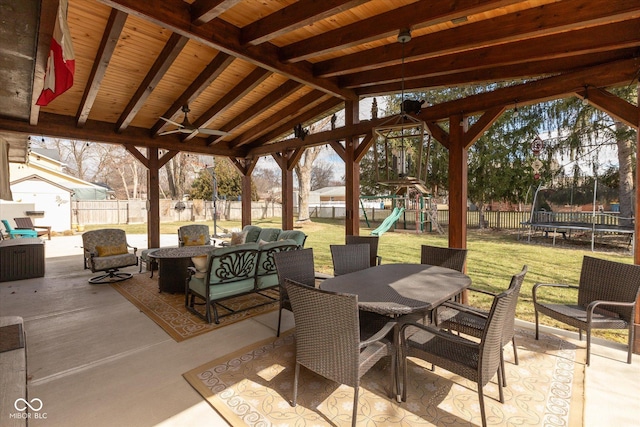 view of patio / terrace featuring a fenced backyard, a trampoline, an outdoor living space, a playground, and outdoor dining space