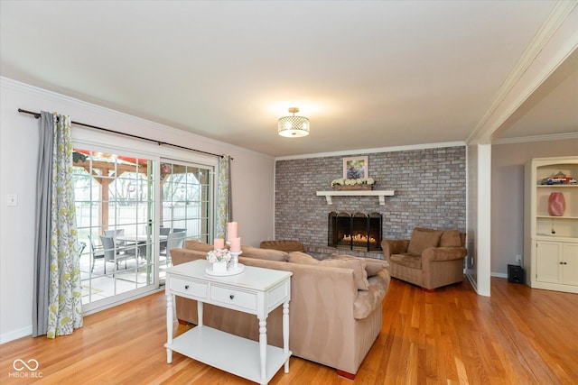 living room with baseboards, ornamental molding, a brick fireplace, and light wood-style floors