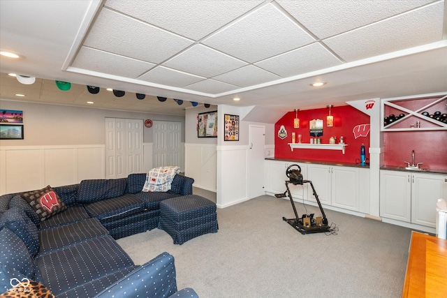 living area with a paneled ceiling, recessed lighting, a wainscoted wall, indoor wet bar, and carpet