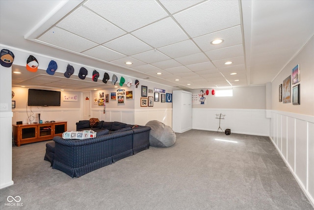 carpeted living area with recessed lighting, a wainscoted wall, and a paneled ceiling