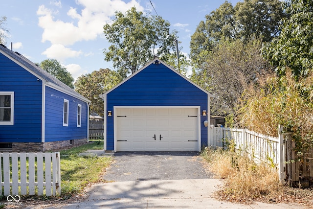 detached garage featuring fence